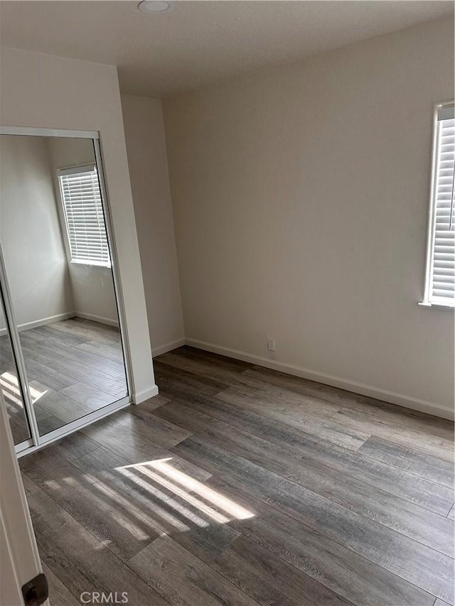 unfurnished bedroom featuring dark hardwood / wood-style flooring and a closet