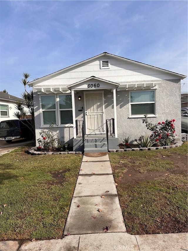 bungalow-style house featuring a front lawn