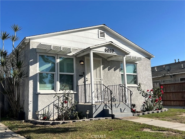 bungalow-style home with a front yard