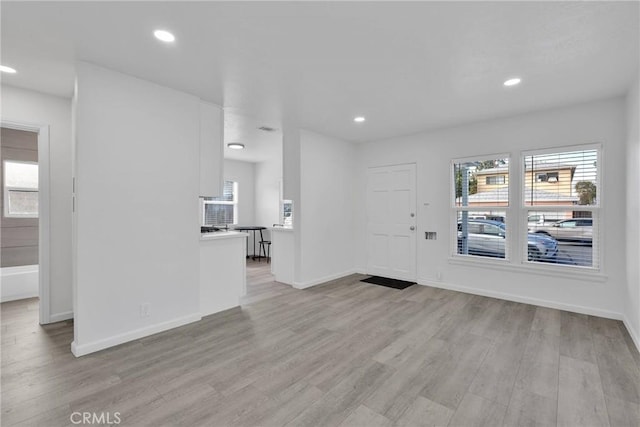 entryway with baseboards, light wood finished floors, and recessed lighting