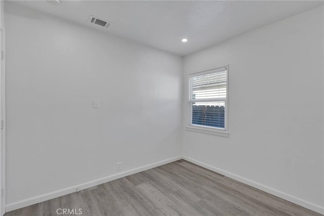 empty room featuring recessed lighting, wood finished floors, visible vents, and baseboards