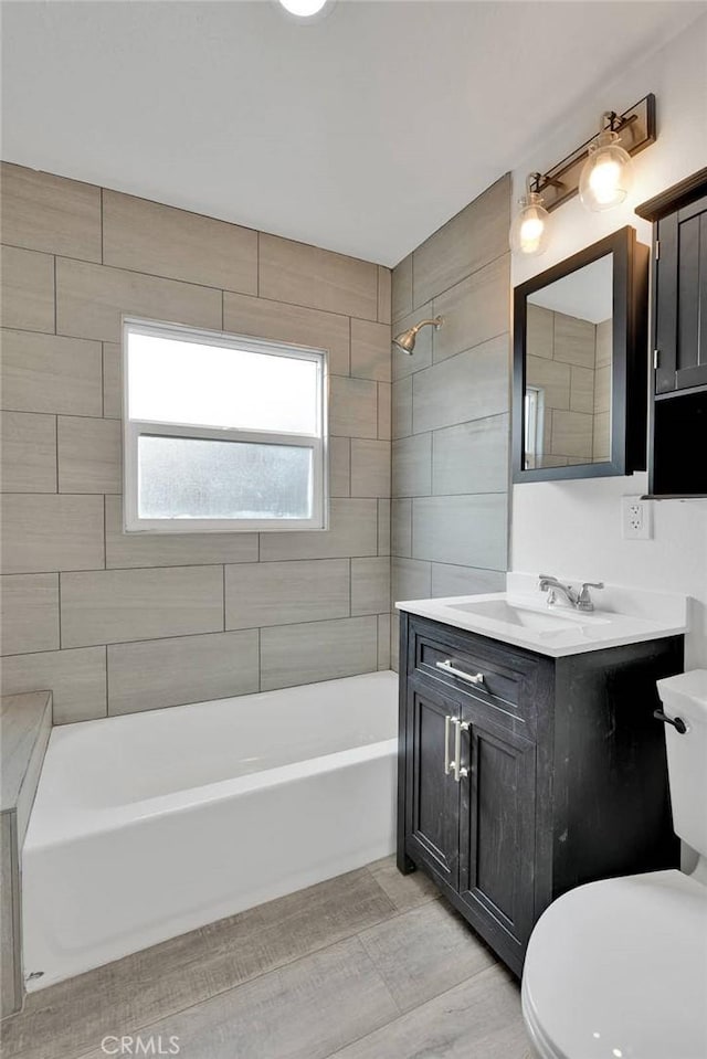 bathroom with bathtub / shower combination, vanity, and toilet