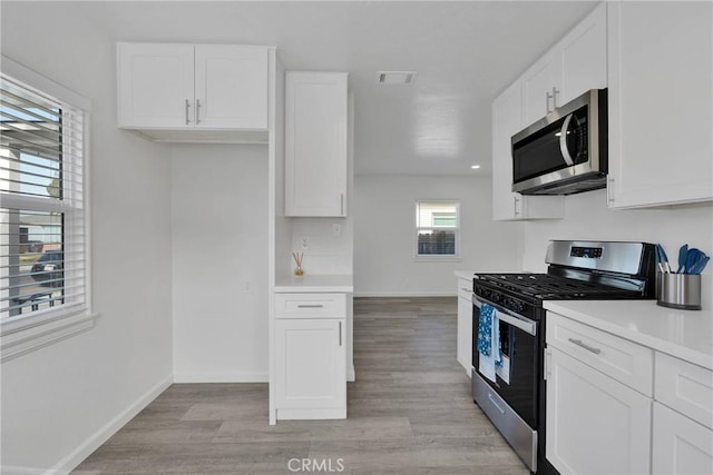 kitchen featuring visible vents, white cabinetry, baseboards, light countertops, and appliances with stainless steel finishes