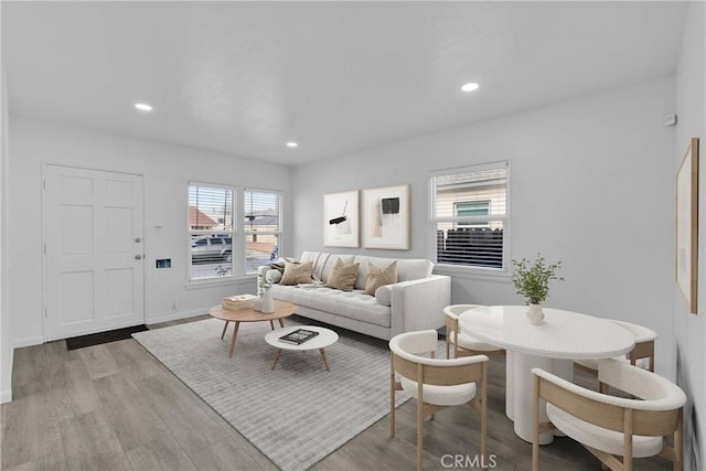 living area with baseboards, recessed lighting, and light wood-style floors