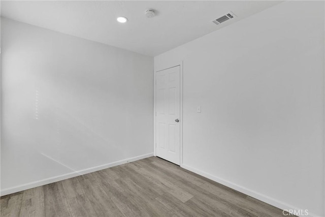 unfurnished room with baseboards, visible vents, wood finished floors, and recessed lighting