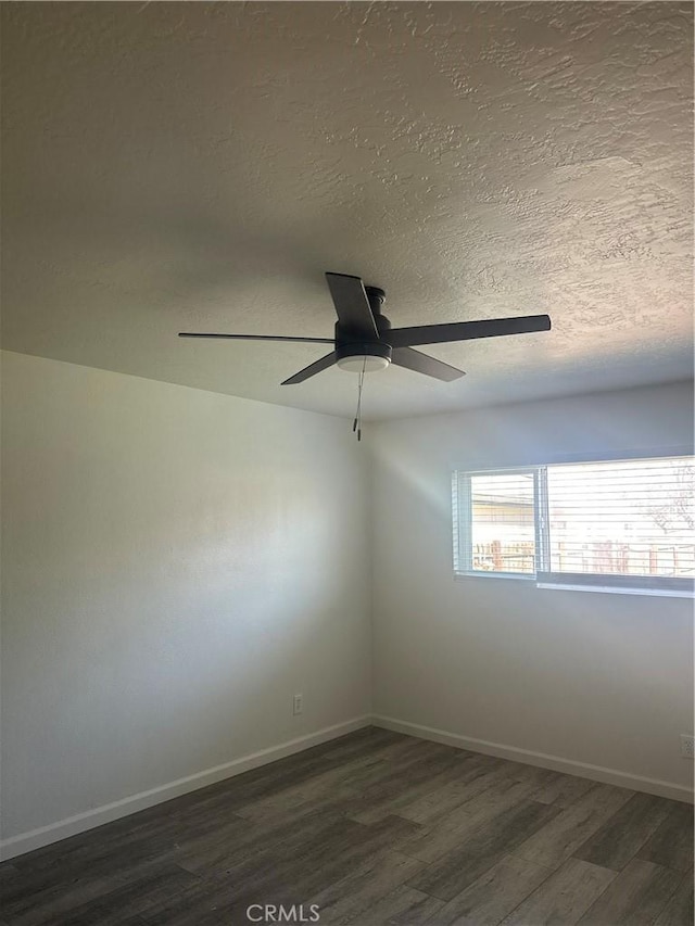 spare room featuring ceiling fan, a textured ceiling, baseboards, and wood finished floors