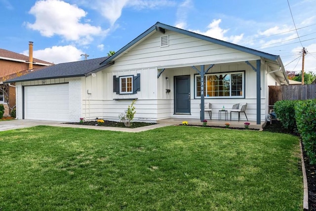 view of front of house featuring a porch, a garage, and a front lawn