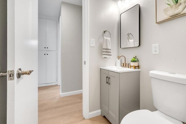 bathroom with vanity, wood-type flooring, and toilet