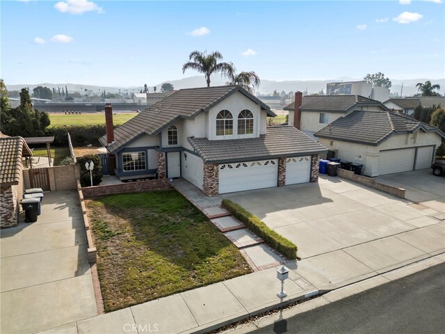 front of property featuring a front yard, a garage, and a mountain view