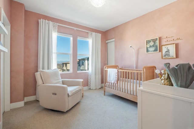 bedroom featuring light carpet and a crib