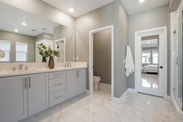 bathroom with toilet, a shower with door, and vanity