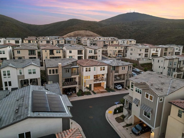 aerial view at dusk featuring a mountain view