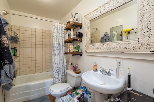 full bathroom featuring toilet, sink, and shower / bathtub combination with curtain