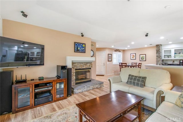 living room featuring light hardwood / wood-style floors and a stone fireplace