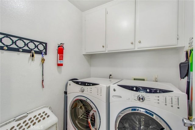 laundry room featuring cabinets and washing machine and clothes dryer