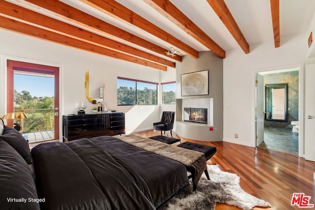 bedroom featuring beamed ceiling, hardwood / wood-style floors, access to outside, and multiple windows