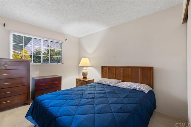 bedroom with a textured ceiling and light colored carpet