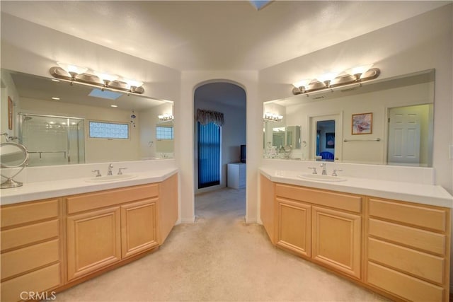 bathroom with a shower with shower door and vanity