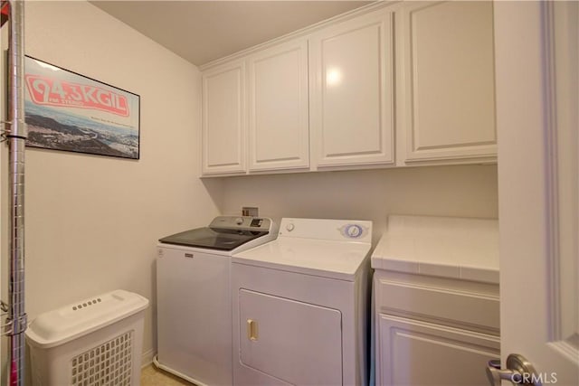 clothes washing area with cabinets and independent washer and dryer