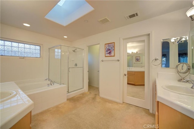 bathroom with vanity, a skylight, and independent shower and bath