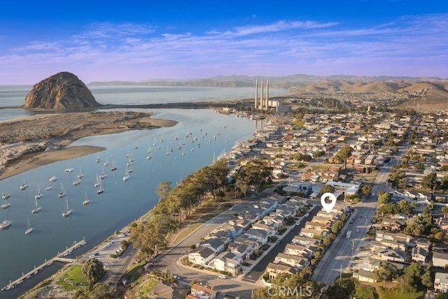 aerial view at dusk featuring a water and mountain view