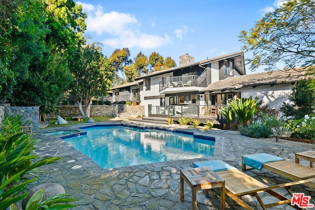 view of pool with an in ground hot tub, a wooden deck, and a patio