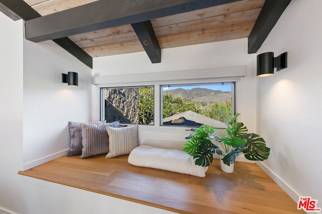 living area with vaulted ceiling with beams, wood ceiling, and hardwood / wood-style flooring