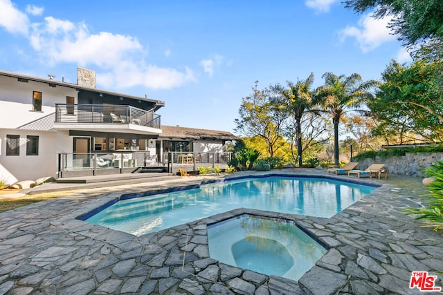 view of pool featuring a patio, a wooden deck, and an in ground hot tub