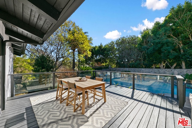 wooden terrace featuring a fenced in pool