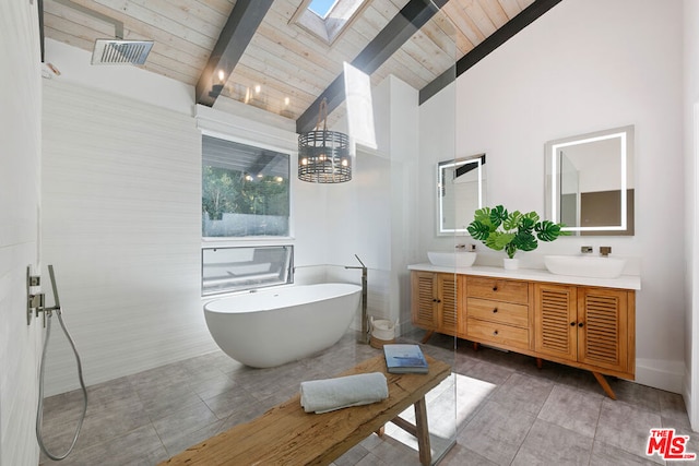 bathroom featuring vaulted ceiling with skylight, a bath, wood ceiling, and vanity