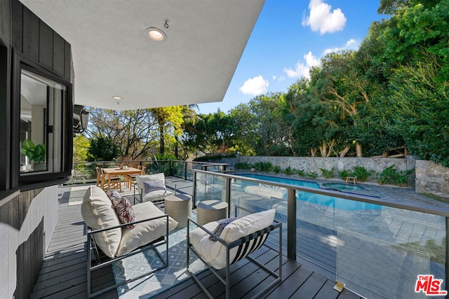 deck featuring an outdoor living space and a swimming pool with hot tub