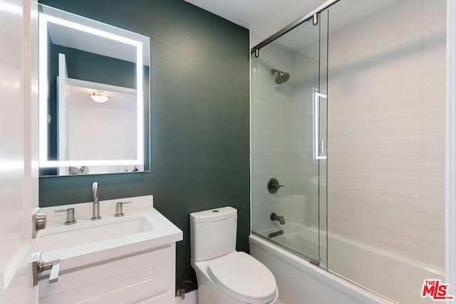 full bathroom with combined bath / shower with glass door, vanity, and toilet