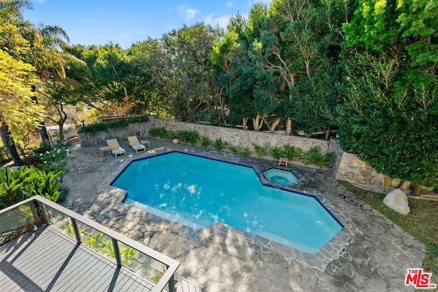 view of swimming pool featuring an in ground hot tub