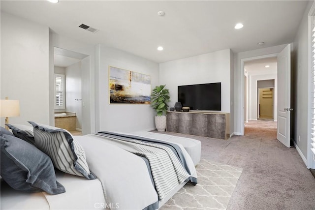 bedroom with light carpet and ensuite bath