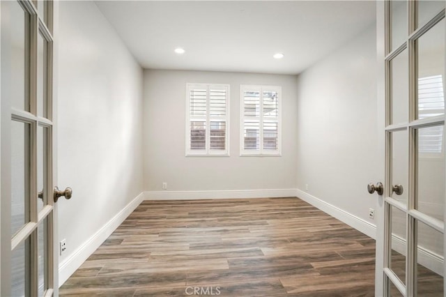 spare room with french doors and hardwood / wood-style floors