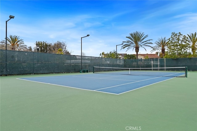 view of tennis court featuring basketball hoop