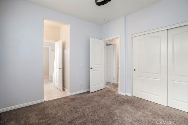 unfurnished bedroom with light colored carpet and a closet