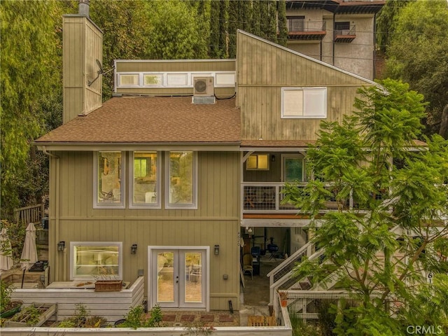 back of house with a balcony and french doors