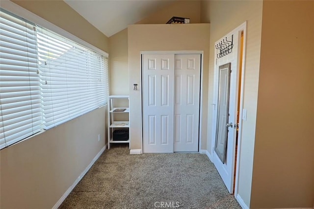 interior space featuring vaulted ceiling and carpet floors