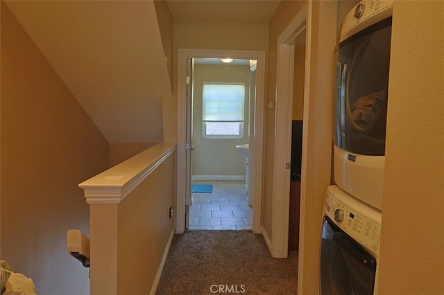 hallway featuring stacked washer and dryer and carpet floors