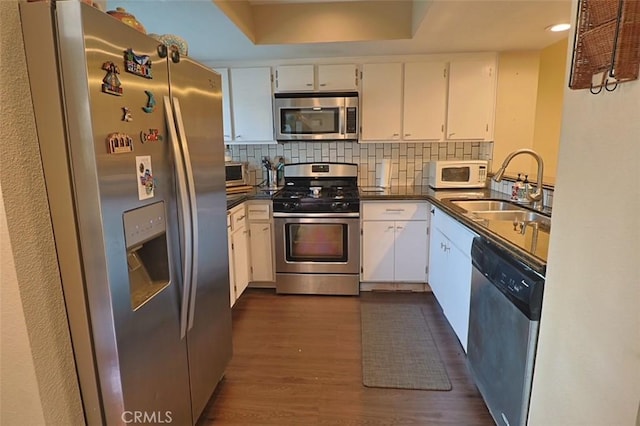 kitchen with sink, white cabinetry, tasteful backsplash, dark hardwood / wood-style flooring, and stainless steel appliances