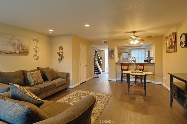 living room with dark hardwood / wood-style floors and ceiling fan