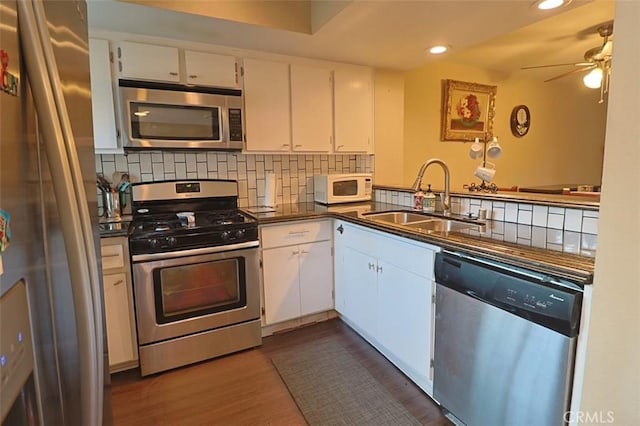 kitchen with stainless steel appliances, white cabinetry, sink, and backsplash