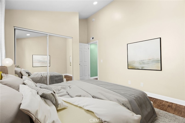 bedroom with lofted ceiling, a closet, and hardwood / wood-style floors