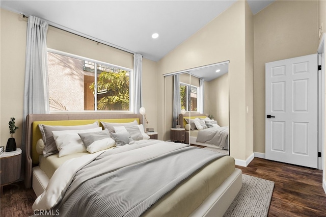 bedroom with a closet, dark hardwood / wood-style flooring, and vaulted ceiling