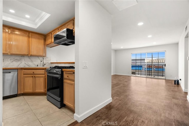 kitchen featuring decorative backsplash, a tray ceiling, dishwasher, ornamental molding, and black range with gas stovetop