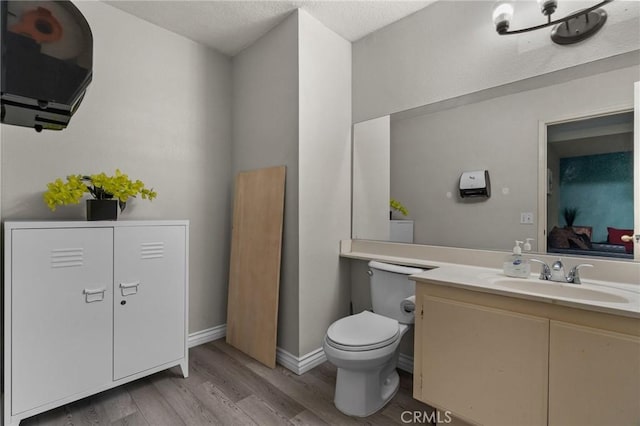 bathroom featuring toilet, vanity, and hardwood / wood-style flooring