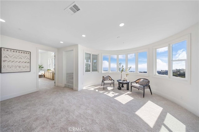 sitting room featuring light carpet and a healthy amount of sunlight