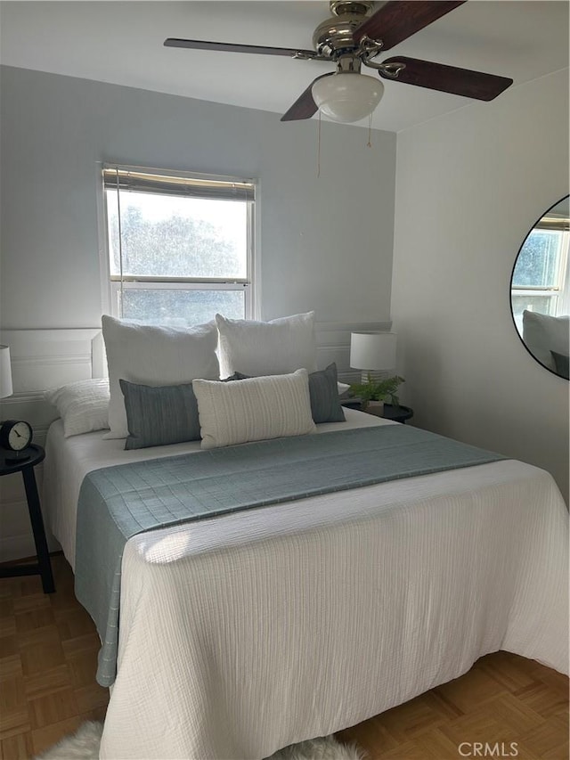 bedroom featuring ceiling fan and parquet floors