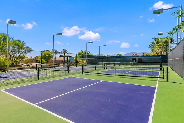 view of tennis court featuring basketball hoop